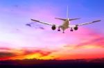 Commercial Airplane Flying At Sunset Stock Photo