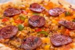 Delicious Baked Salami Pizza Served On Rustic Wooden Table Stock Photo