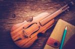 Violin And Notebook With Pencil On Grunge Dark Wood Background Stock Photo