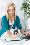 Pretty Young Woman Working And Using Her Mobile Phone Stock Photo