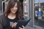 Young Woman Holding A Tablet On The Street Stock Photo