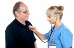 Female Doctor Examining An Elderly Man Stock Photo