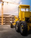 Old Yellow Motor Grader On The Road Stock Photo