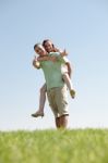 Man Piggybacking His Girlfriend Stock Photo