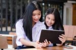 Two Asia Thai High School Student Uniform Best Friends Beautiful Girl Using Her Tablet And Funny Stock Photo