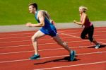 Athletes Running On Race Track Stock Photo