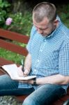 Man Writing In Notepad Stock Photo