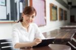 Portrait Of Thai Adult Businesswoman Beautiful Girl Using Her Tablet Stock Photo