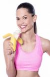 Energetic Woman Eating Banana Stock Photo