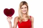 Smiling Teen Girl Showing Heart Shape Gift To Camera Stock Photo