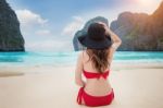 Young Woman In Red Bikini Sitting On The Beach Stock Photo