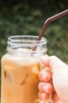 Hand On Glass Of Iced Milk Coffee With Vintage Filter Effect Stock Photo