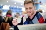 Smiling Man Reading Newspaper At Restaurant Stock Photo