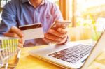 Man Holding Credit Card In Hand And Entering Security Code Using Stock Photo