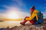 Young Woman Sitting On The Hill Of High Mountains Stock Photo