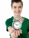 Smiling Boy Showing Alarm Clock Stock Photo