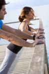 Couple Doing Push Ups Near The Sea Stock Photo