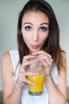 Smiling Woman Drinking Orange Juice At Home Stock Photo