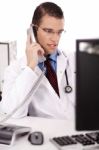 Physician Talking Over Phone Stock Photo