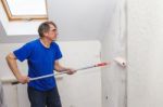 Elderly Worker Painting Wall With Glue Stock Photo