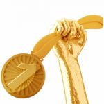 Gold Hand Holding Medal Isolated On White Background Stock Photo