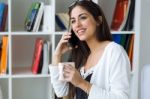 Pretty Young Woman Using Her Mobile Phone In The Office Stock Photo