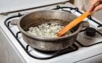 Woman Frying Onions Stock Photo