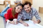 Young Couple Looking At The Blueprints Of Their New Home Stock Photo