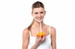 Girl Sipping Orange Juice Through Straw Stock Photo