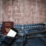 Blue Jeans With Cell Phone And Passport In A Pocket Background Stock Photo