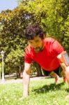 Urban Athlete Doing Push-ups Exercises On The Grass Stock Photo