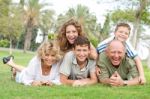 Multi-generation Family Relaxing In Park Stock Photo