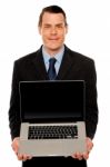 Smart Businessman Displaying Laptop To You Stock Photo