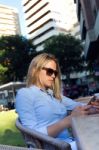 Beautiful Young Woman Using Her Mobile Phone In A Restaurant Ter Stock Photo