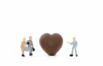 Miniature Worker Making Heart Shaped Chocolate On White Background Stock Photo