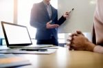 Businesswoman Asking Question During Her Colleagues Presentation Stock Photo