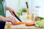 Pretty Young Woman Cutting Vegetables In The Kitchen Stock Photo