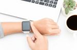 Woman Touching Smart Watch Hand On Work Desk Stock Photo