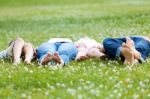 Happy Young Family Lying On Grass Stock Photo