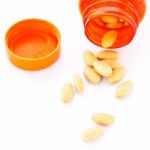 Closeup Of Orange Pills And Pill Bottle Stock Photo