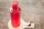 Red Syrup In The Bottle On Wooden Plate Stock Photo