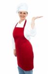 Smiling Lady Chef Showing Open Palm Stock Photo