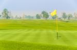 Golf Ball Near Hole On Green With Yellow Flag Stock Photo