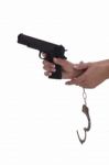 Woman's Hand With Handcuffs And Gun On A White Background Stock Photo