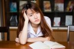 Portrait Of Thai Adult Student University Uniform Beautiful Girl Reading Red Book Stock Photo