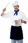 Smiling Chef Showing Kitchen Essentials Stock Photo