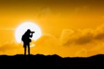 Silhouette Of Photographer With Camera At Sunset Stock Photo