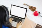 Asian Girl Sitting On Bed Surfing Internet Or Working On Noteboo Stock Photo