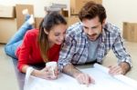 Young Couple Looking At The Blueprints Of Their New Home Stock Photo