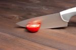 Fresh Cut Tomatoes With Knife On The Dark Wooden Table Stock Photo